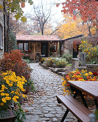 Jardin avec fleurs d'automne et sentier pavé devant un chalet.
