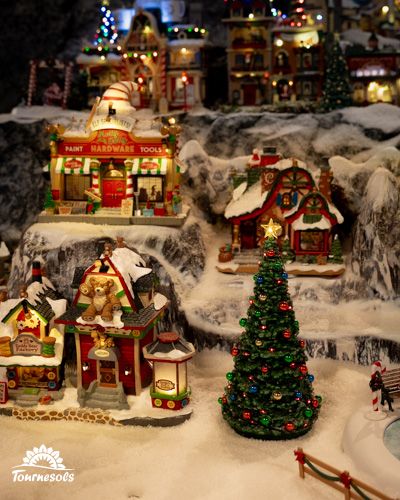 Village Lemax décoratif avec maisons illuminées et sapin de Noël.