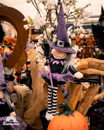 Sorcière en peluche festive parmi les décorations Halloween chez Tournesols.
