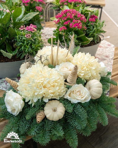 Composition de Toussaint blanc crème : chrysanthèmes, roses, mini-courges et cônes en bois sur branches de sapin